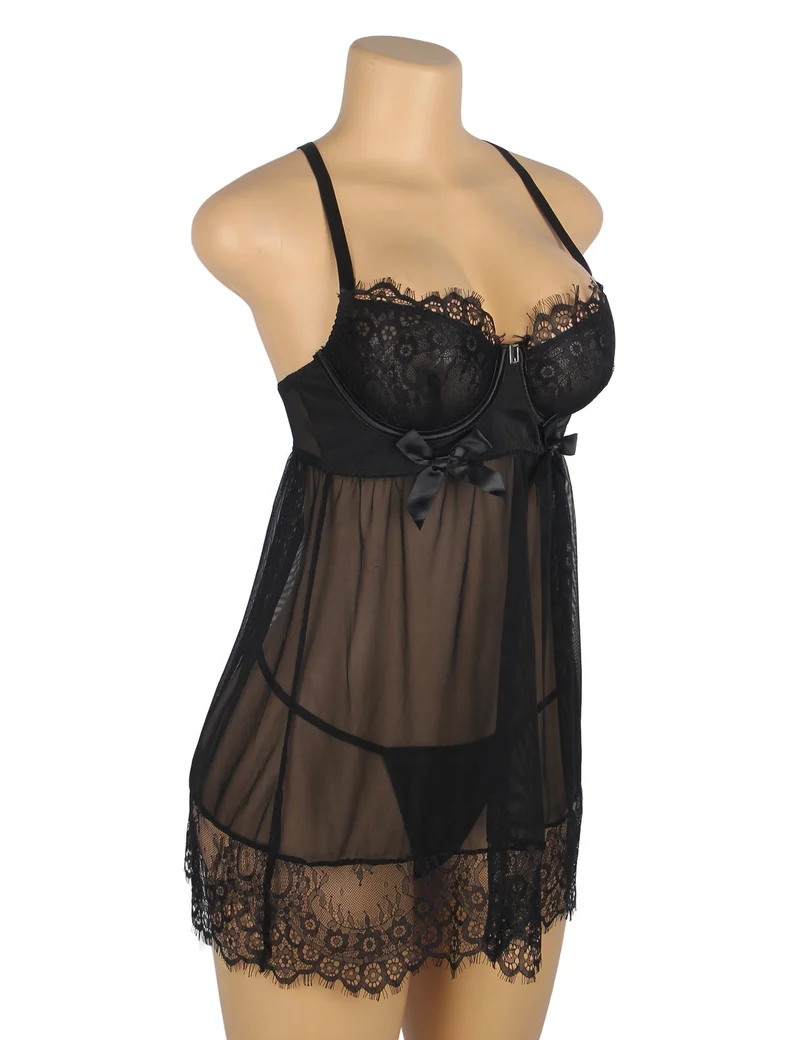 Schwarzes Babydoll aus Netzstoff mit Bügeln und Polsterung, gekreuztem Rückenausschnitt, Wimpernspitze an Brust und Saum, Schleife am Dekolleté und passendem Höschen.